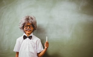Child dressed up as a professor with a stick of chalk